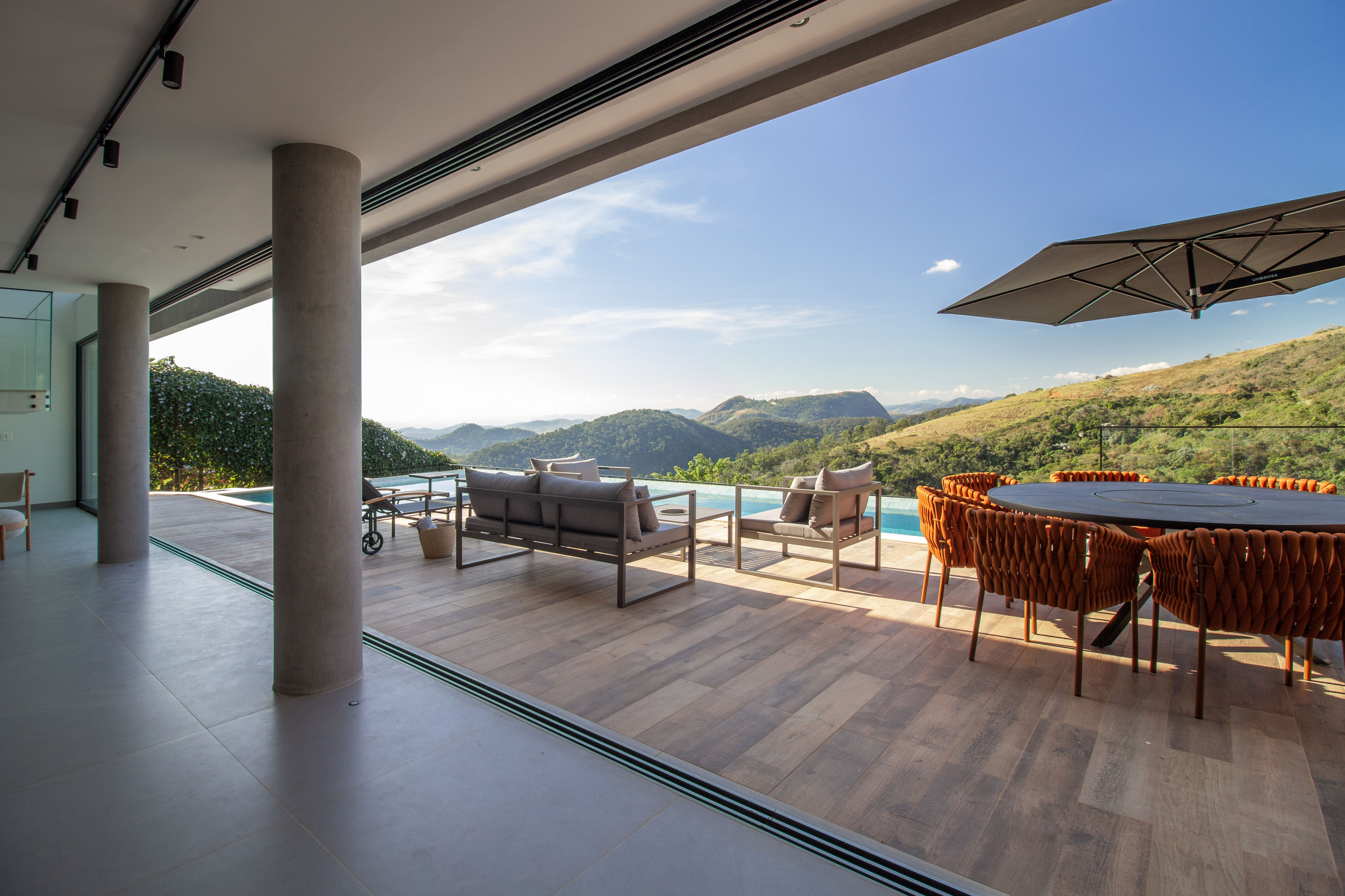 Casa de 720 m² fica no topo de uma montanha no RJ. Projeto de Rafael Ramos. Na foto, varanda integrada com área interna da casa.