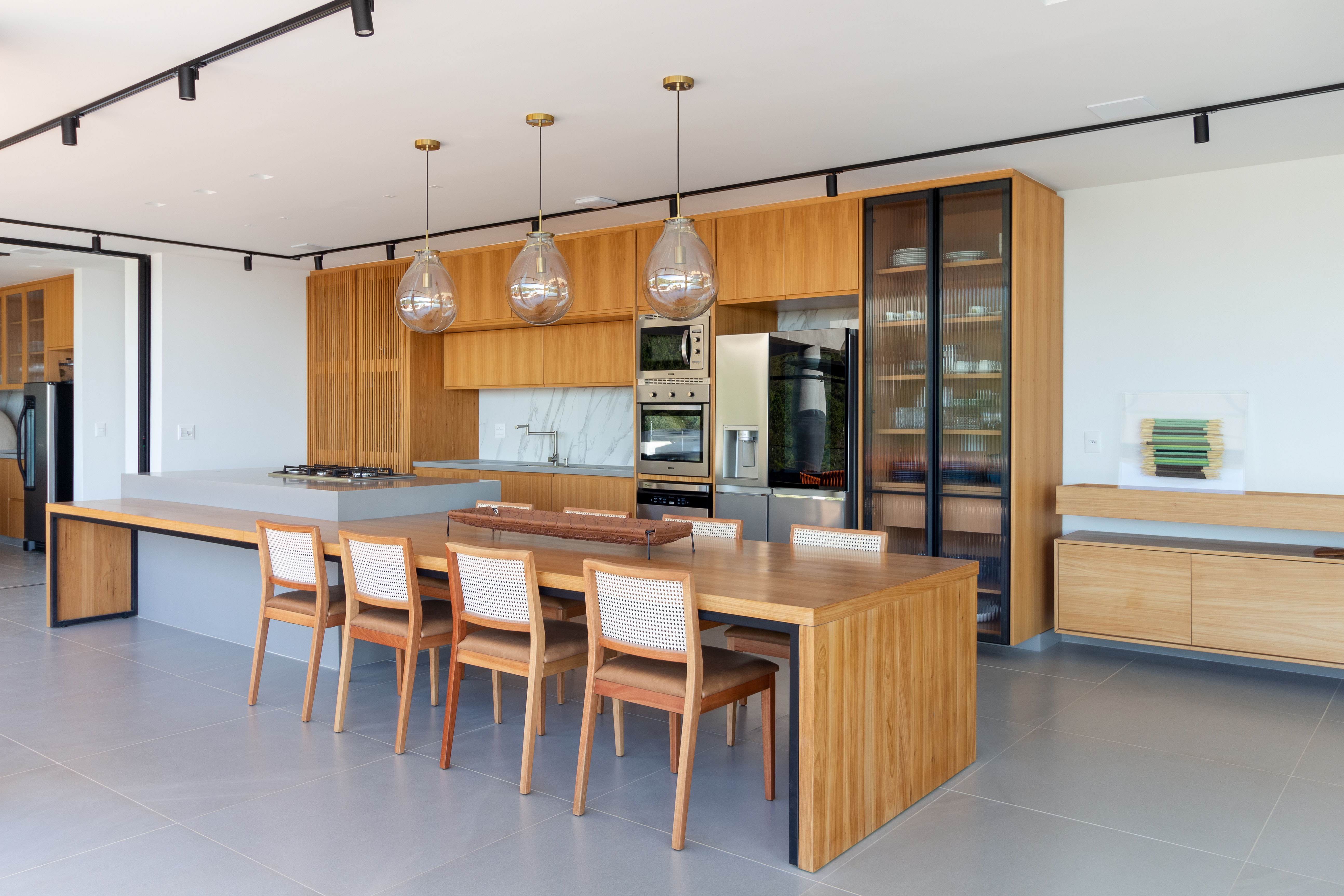 Casa de 720 m² fica no topo de uma montanha no RJ. Projeto de Rafael Ramos. Na foto, cozinha com marcenaria em madeira clara.
