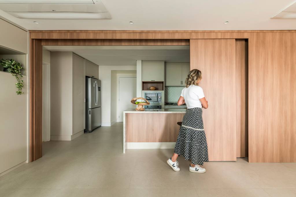 Lareira, adega e cervejaria: apê de 197 m² é um convite ao lazer. Projeto de Mariana Leal. Na foto, painel que separada cozinha dos outros ambientes do apartamento.