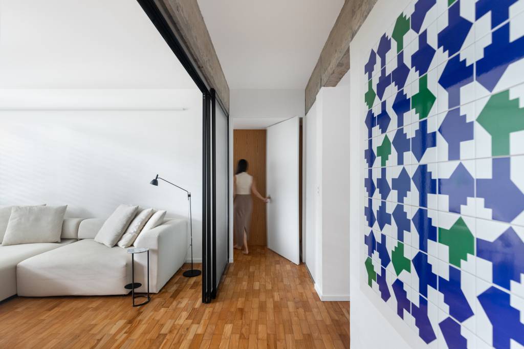 Apartamento reformado tem layout aberto e integrado para receber. Corredor.