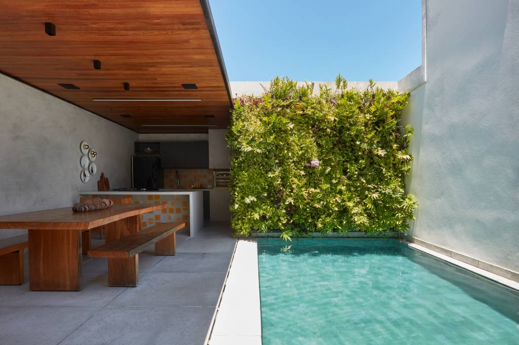 Cobertura tem móveis de madeira de demolição, jardim vertical e piscina em pedra Hijau