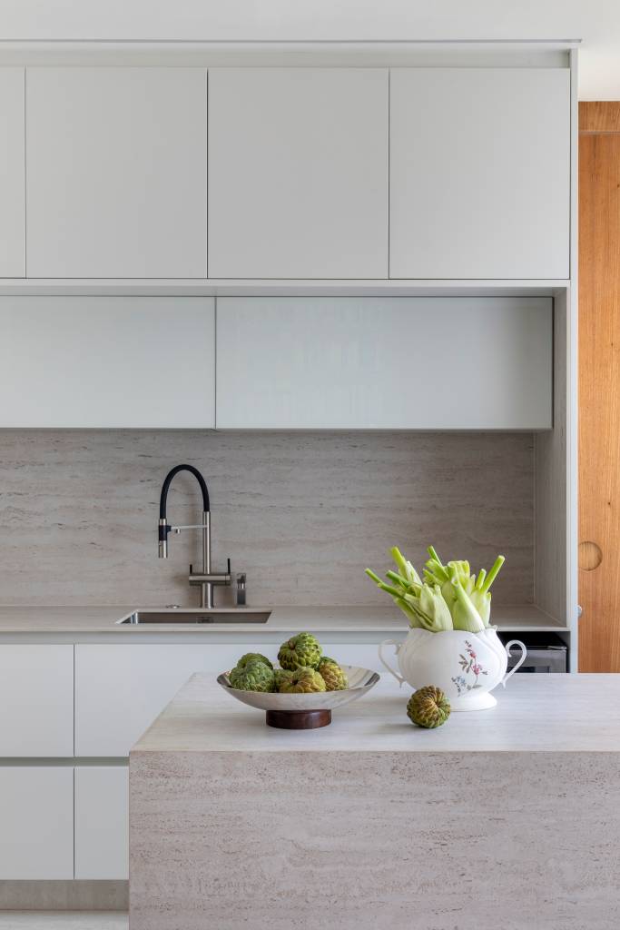 Cozinha de ape de 80 m² é minimalista com laca branca na marcenaria. Projeto de João Panaggio. Na foto, ilha de cozinha.
