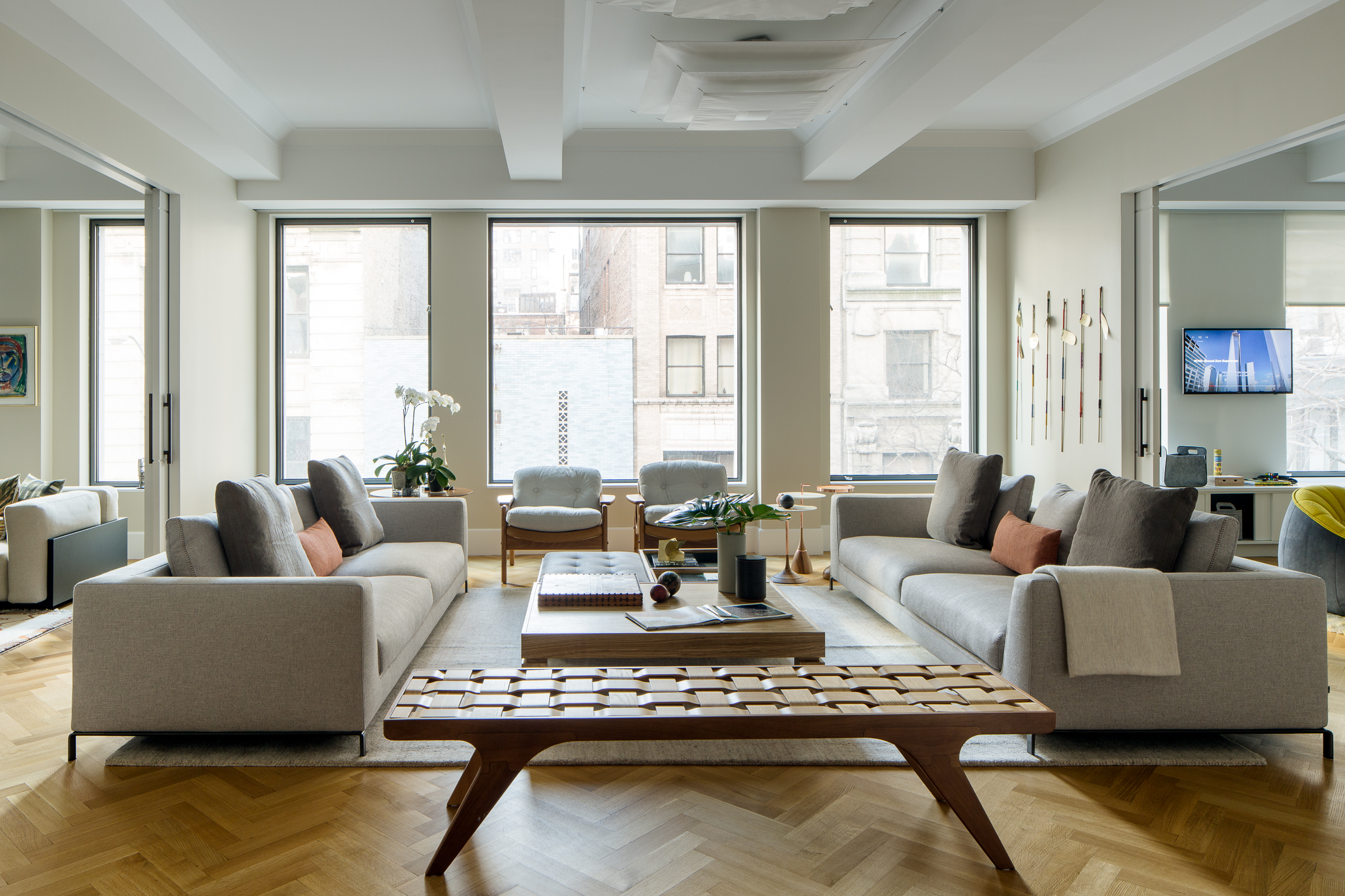 Decoração de apartamento em Nova York traz artesanato e design brasileiro. Projeto Mauricio Nóbrega. Na foto, sala de estar, sofá cinza, mesas de centro de madeira.