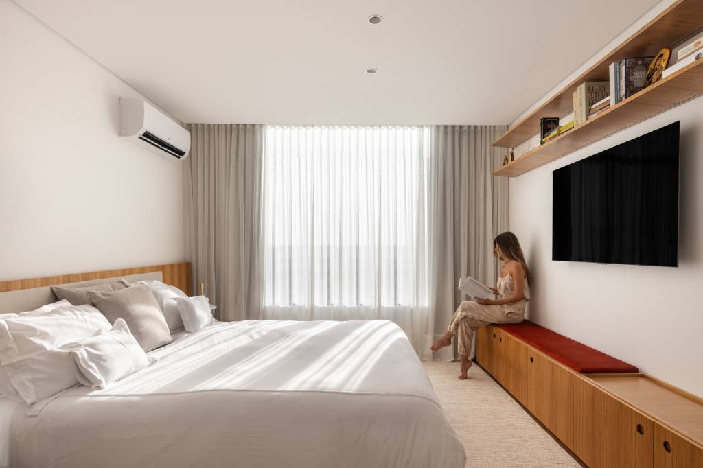 Forro de madeira e painel de mármore são destaques em área social de apartamento. Quarto.