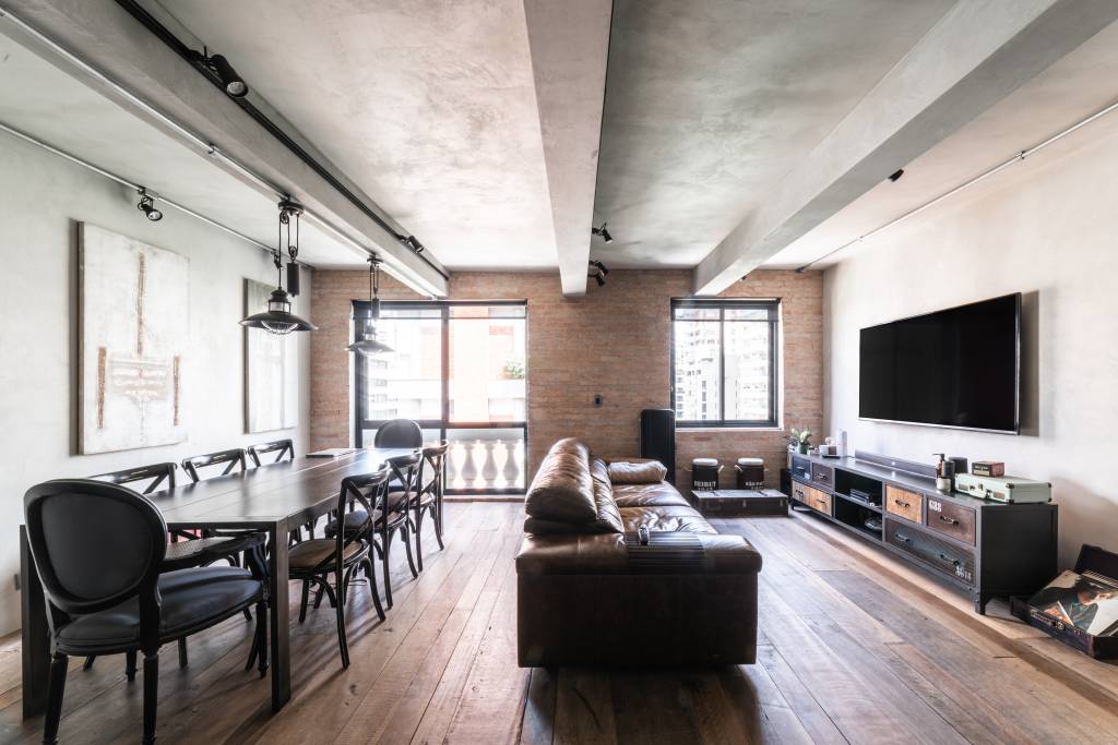 Porta em aço corten integra cozinha e sala de apartamento de 100 m². Projeto de André Ávila Arquitetura