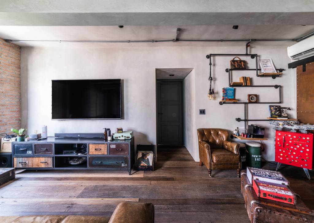 Porta em aço corten integra cozinha e sala de apartamento de 100 m². Projeto de André Ávila Arquitetura