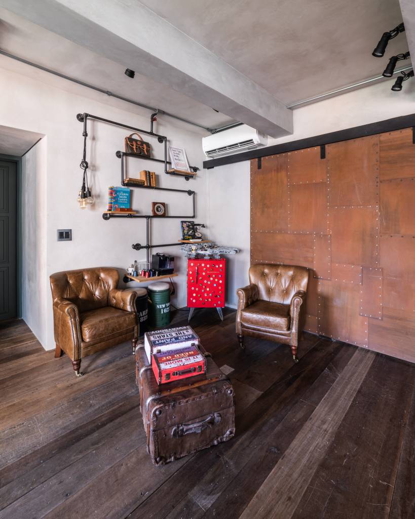 Porta em aço corten integra cozinha e sala de apartamento de 100 m². Projeto de André Ávila Arquitetura