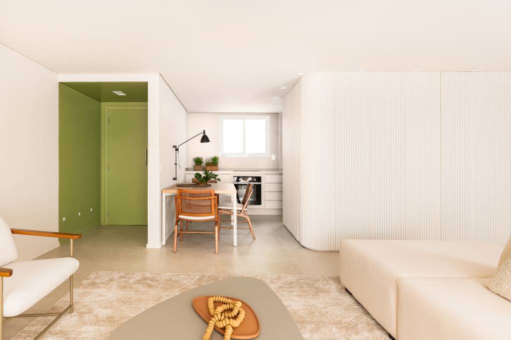 Reforma de apartamento de 67 m² une memória afetiva, design e funcionalidade. Projeto de Degradê Arquitetura. Vista do living para cozinha e hall verde.