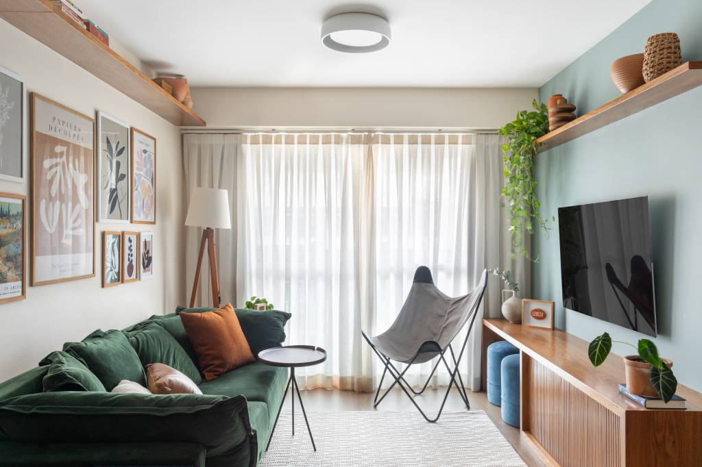 Renovação econômica deixa apê de 70 m² mais colorido com laranja e verde. Projeto Co+Lab Juntos Arquitetura. Na foto, sala, cortina, sofá verde.