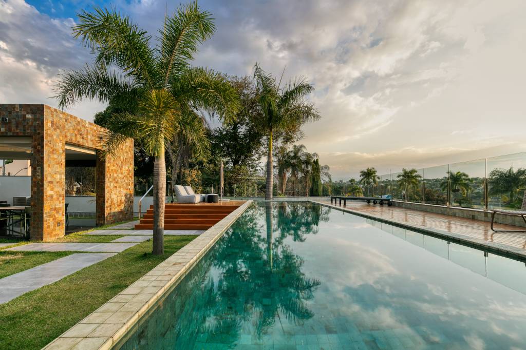 Tons neutros e grandes aberturas valorizam a vista de casa na Pampulha. Externa com piscina.
