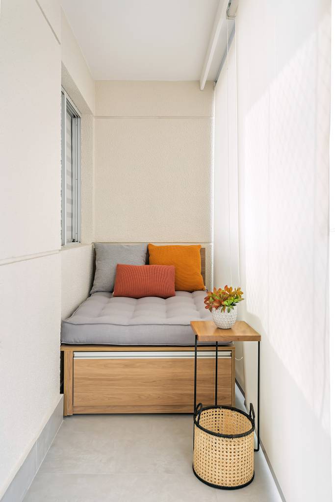 Neste apartamento de 103 m², cristaleira multifuncional também é adega. Projeto de RMV Interiores. Na foto, varanda pequena, banco com futon.
