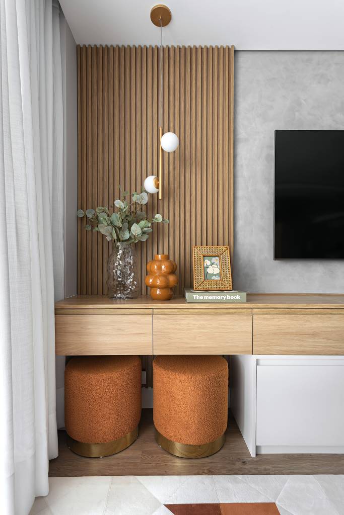 Neste apartamento de 103 m², cristaleira multifuncional também é adega. Projeto de RMV Interiores. Na foto, sala, pufes laranja, painel ripado.