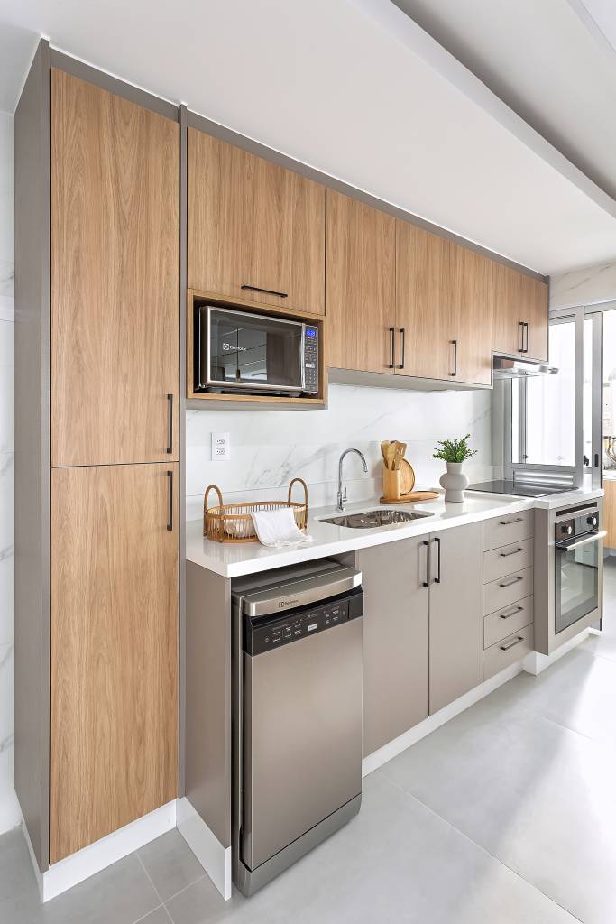 Neste apartamento de 103 m², cristaleira multifuncional também é adega. Projeto de RMV Interiores. Na foto, cozinha, bancada de quartzo branco.
