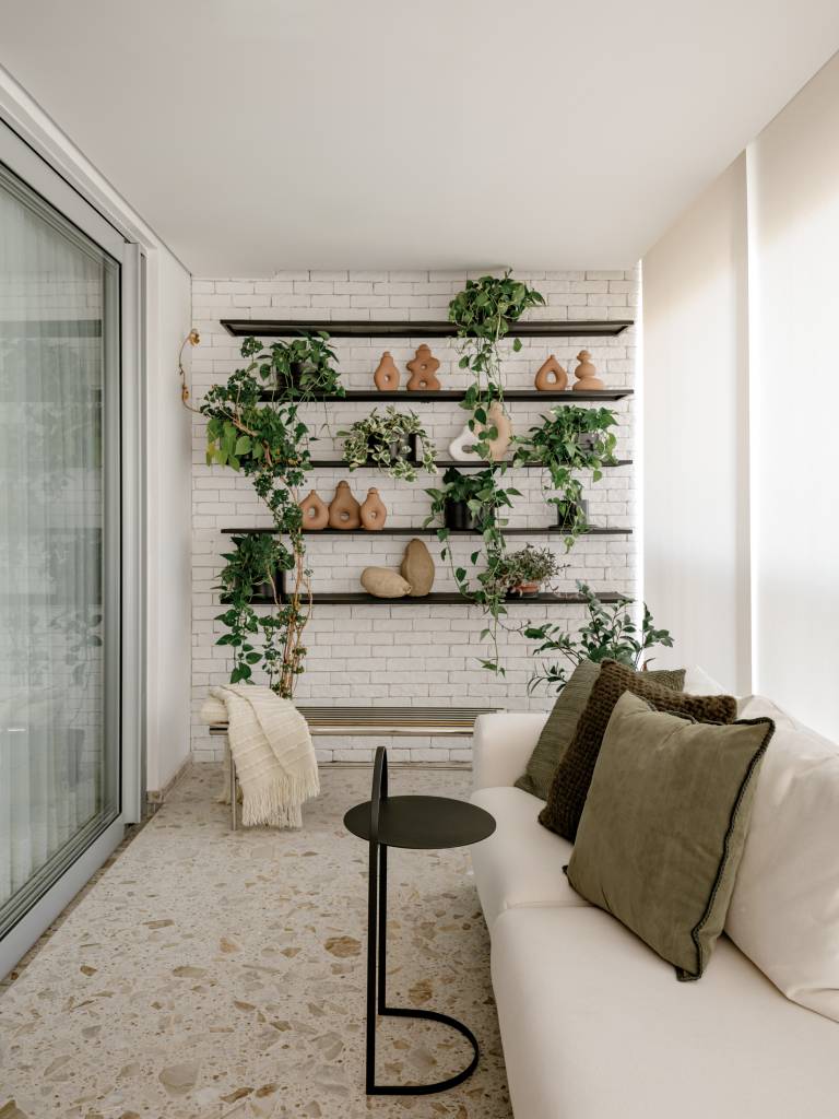 Apartamento de 120 m² tem jardim charmoso em prateleiras na varanda. Projeto de Rua 141 Arquitetura.
