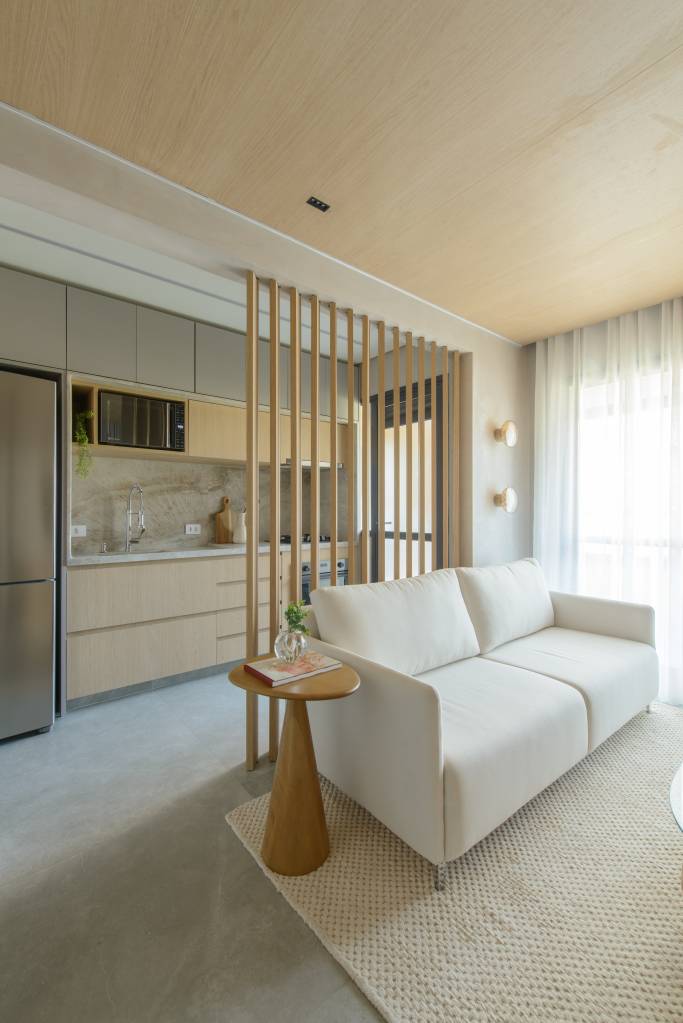 Apê de 56 m² em tons de bege tem divisória articulada entre sala e cozinha. Projeto de Ana Carolina Queiroz Arquitetura.