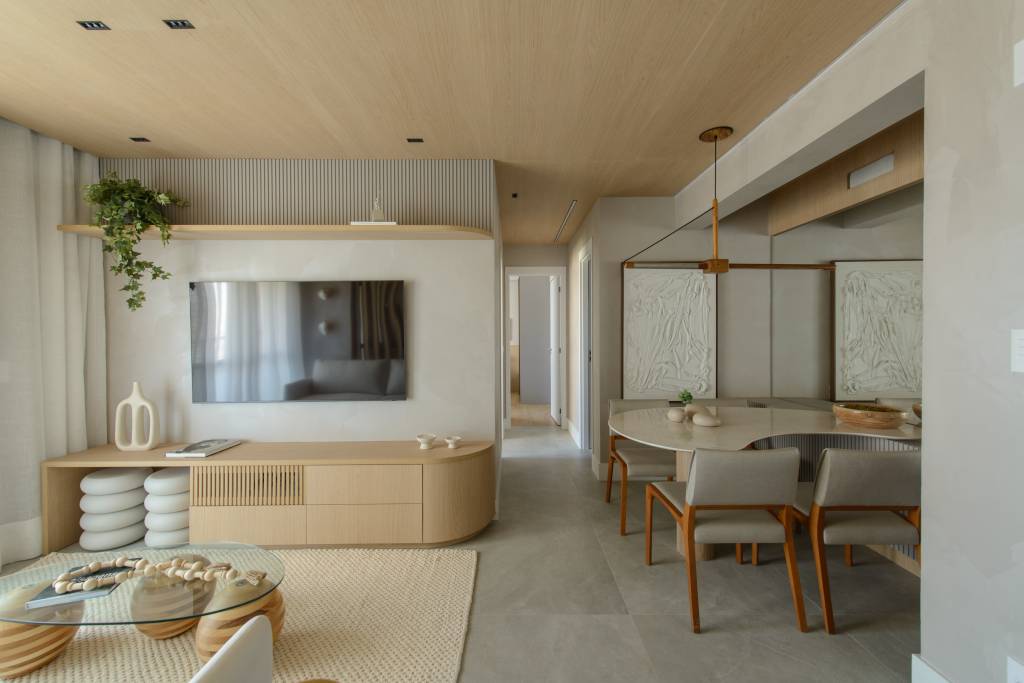 Apê de 56 m² em tons de bege tem divisória articulada entre sala e cozinha. Projeto de Ana Carolina Queiroz Arquitetura.