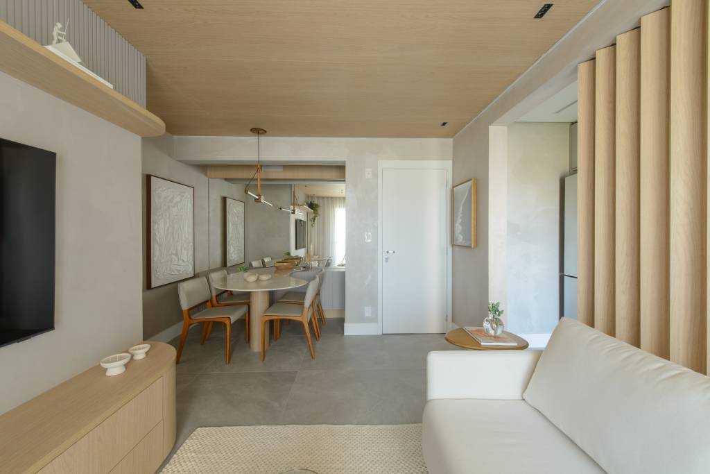 Apê de 56 m² em tons de bege tem divisória articulada entre sala e cozinha. Projeto de Ana Carolina Queiroz Arquitetura.
