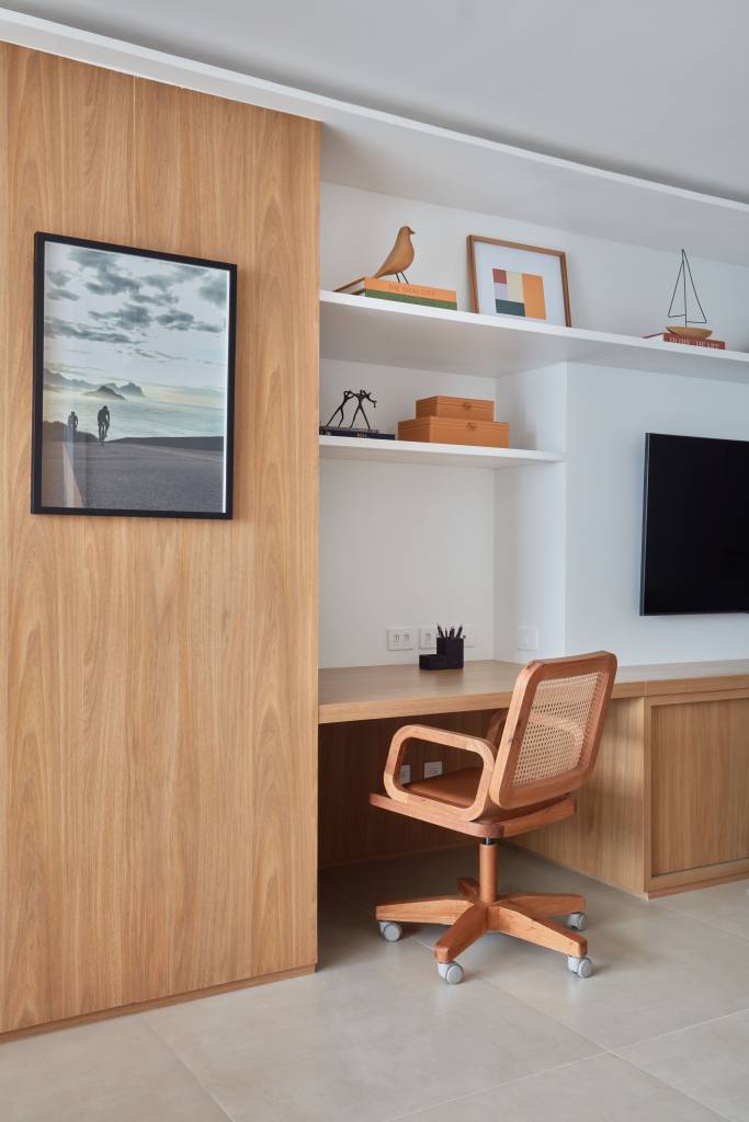 Apê de 50 m² tem portas de correr e bancada de trabalho na estante. Projeto de Carolina Gouvea Arquitetura. Na foto, home office.
