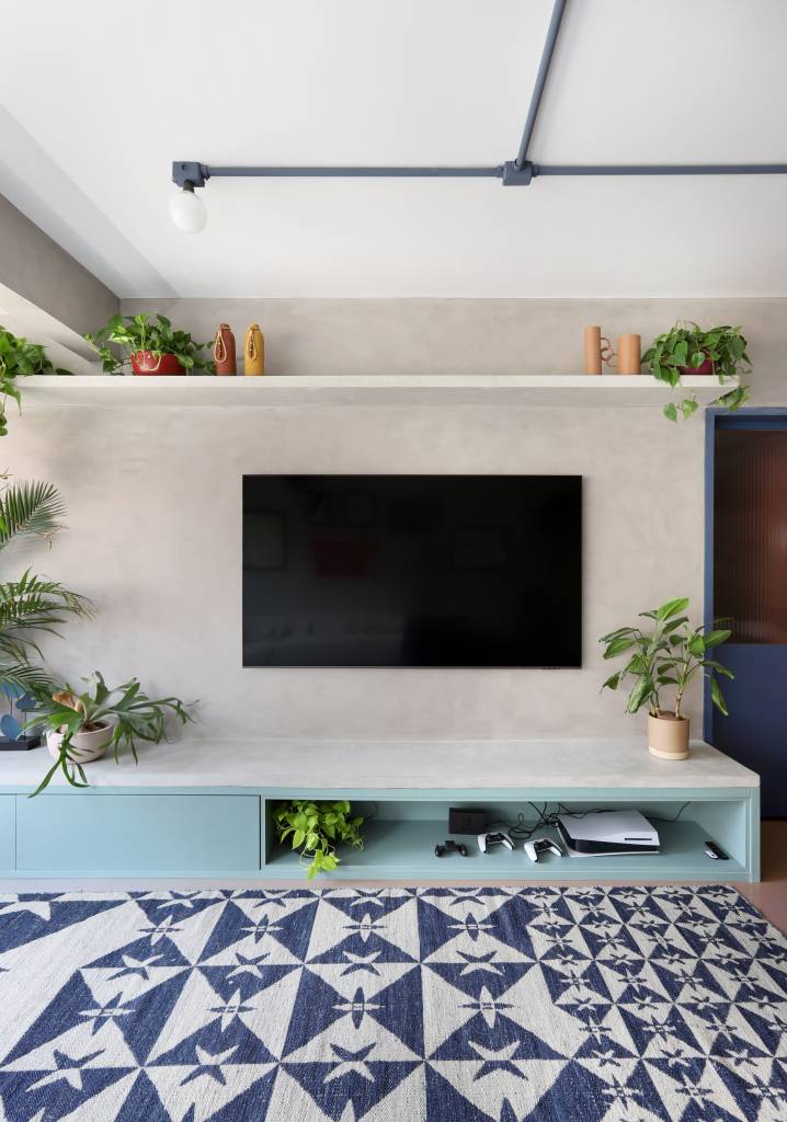 Apê tem paleta com 30 cores alegres e aparador com floreira. Projeto de Studio 92 Arquitetura. Na foto, sala, tapete estampado, plantas.