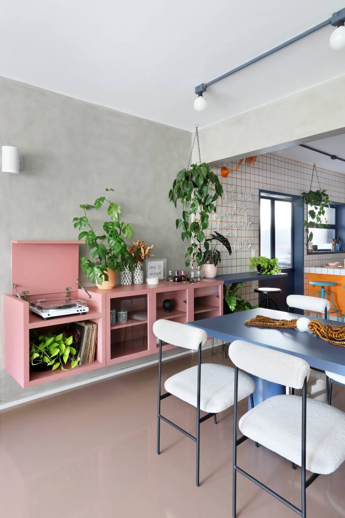 Apê tem paleta com 30 cores alegres e aparador com floreira. Projeto de Studio 92 Arquitetura. Na foto, sala de jantar, aparador rosa.