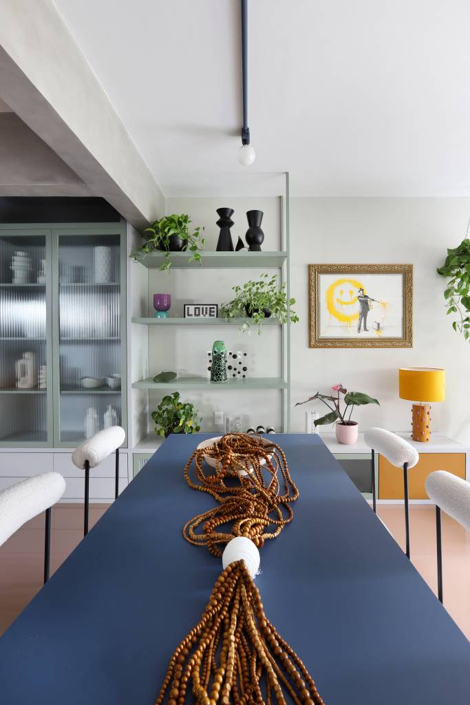 Apê tem paleta com 30 cores alegres e aparador com floreira. Projeto de Studio 92 Arquitetura. Na foto, sala de jantar, mesa azul.
