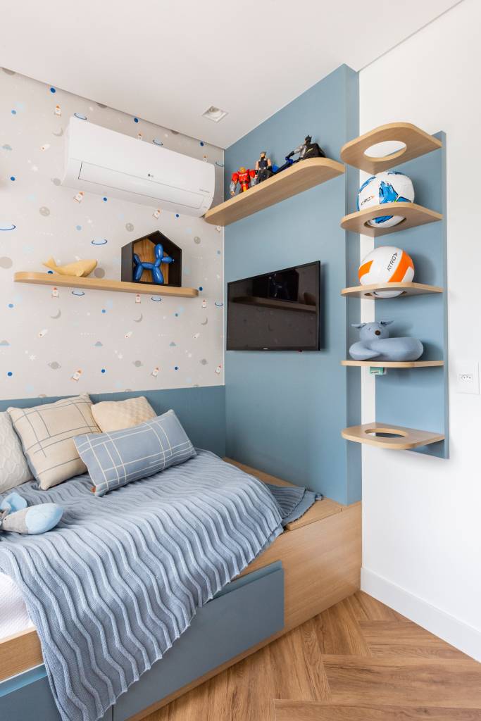 Azul é protagonista em apê com varanda integrada e área gourmet. Projeto de Mari Milani, quarto infantil.