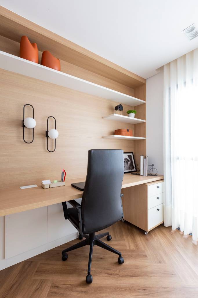Azul é protagonista em apê com varanda integrada e área gourmet. Projeto de Mari Milani, home office.