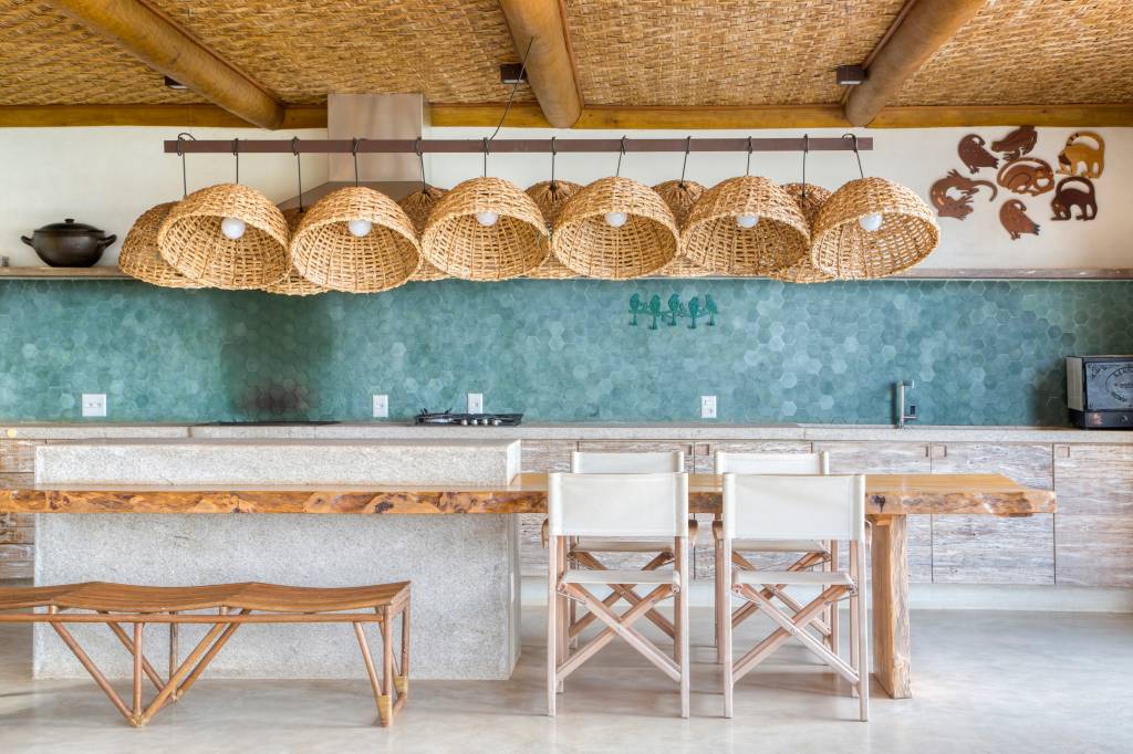 Linda casa de campo tem estrutura de eucalipto e décor rústico chic. Projeto de Solange Calio. Na foto, área gourmet, parede de azulejos, luminária de palha.