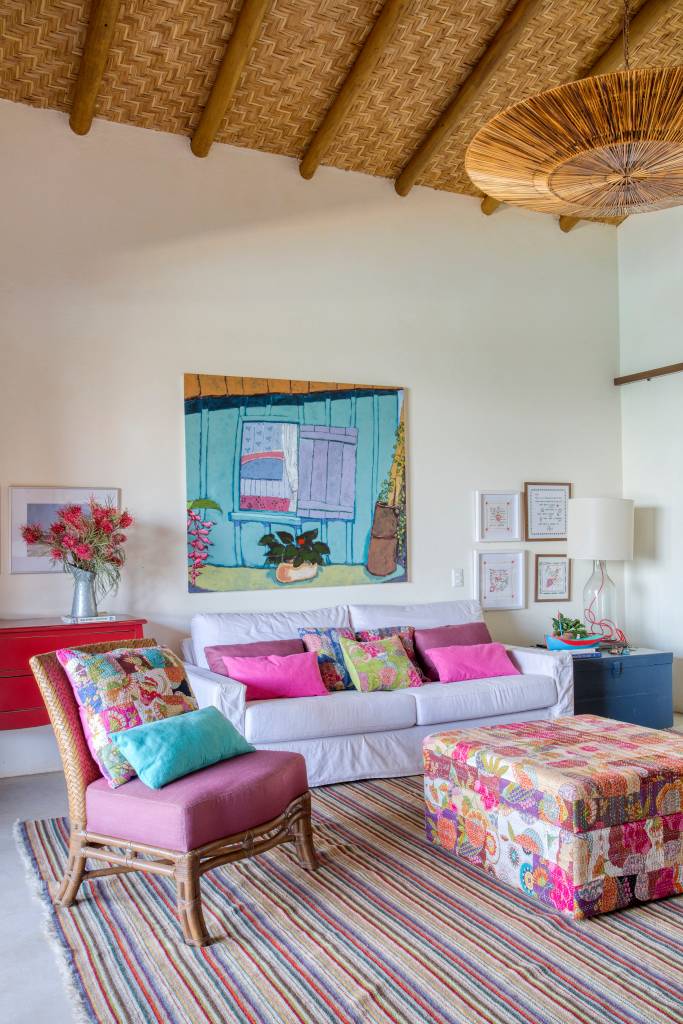 Linda casa de campo tem estrutura de eucalipto e décor rústico chic. Projeto de Solange Calio. Na foto, sala, tapete colorido, estilo boho.