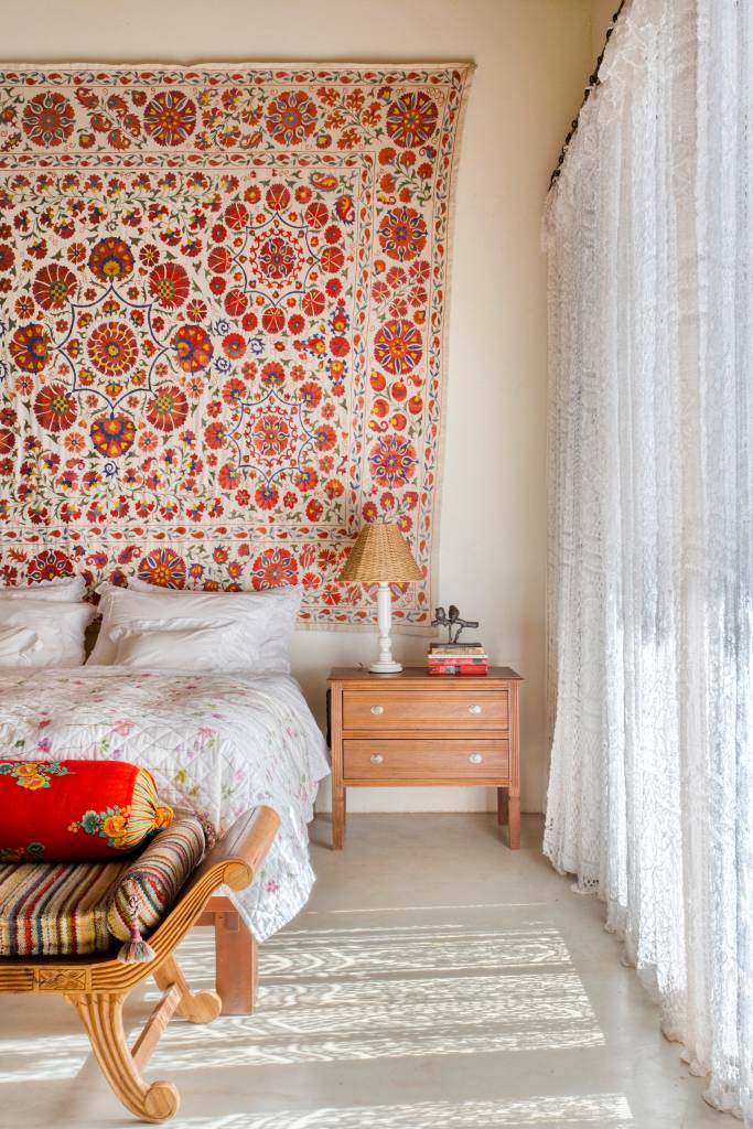 Linda casa de campo tem estrutura de eucalipto e décor rústico chic. Projeto de Solange Calio. Na foto, quarto, estilo boho, lenço na parede.