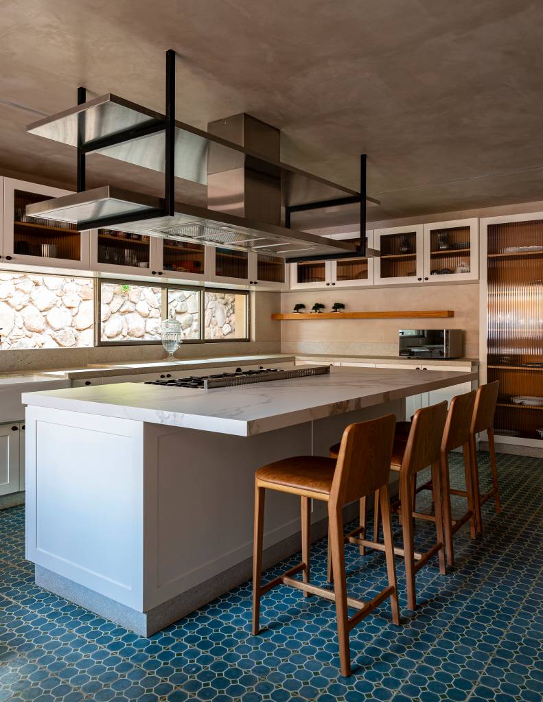Casa de campo tem piscina semiolímpica e oito suítes elegantes. Projeto de Studio DWG. Na foto, cozinha com ilha, piso de ladrilho hidráulico azul.