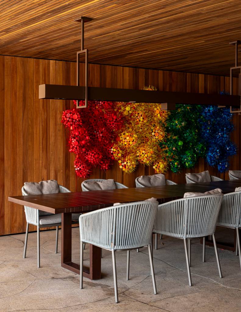 Casa de campo tem piscina semiolímpica e oito suítes elegantes. Projeto de Studio DWG. Na foto, sala de jantar, obra de arte colorida na parede.