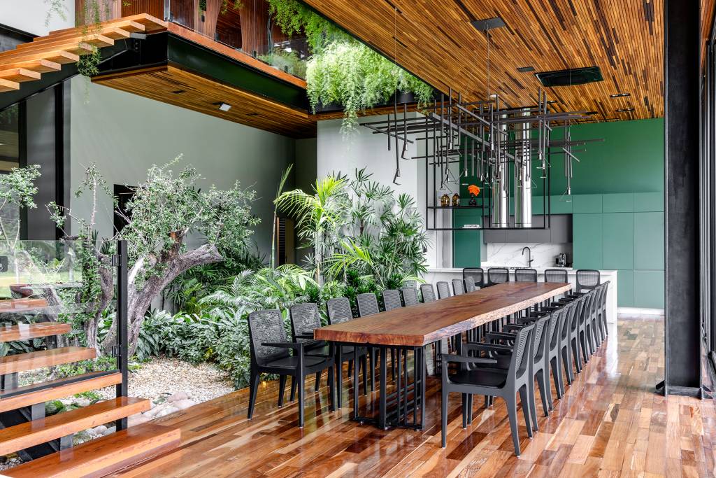 Casa de praia tem pub temático no subsolo, jardim interno e telhado verde