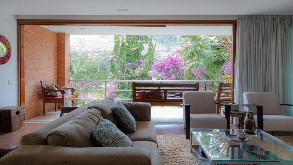 Casa em Teresópolis tem esquadrias, tijolinhos e cimento queimado na fachada. Projeto de Viviane Cunha.