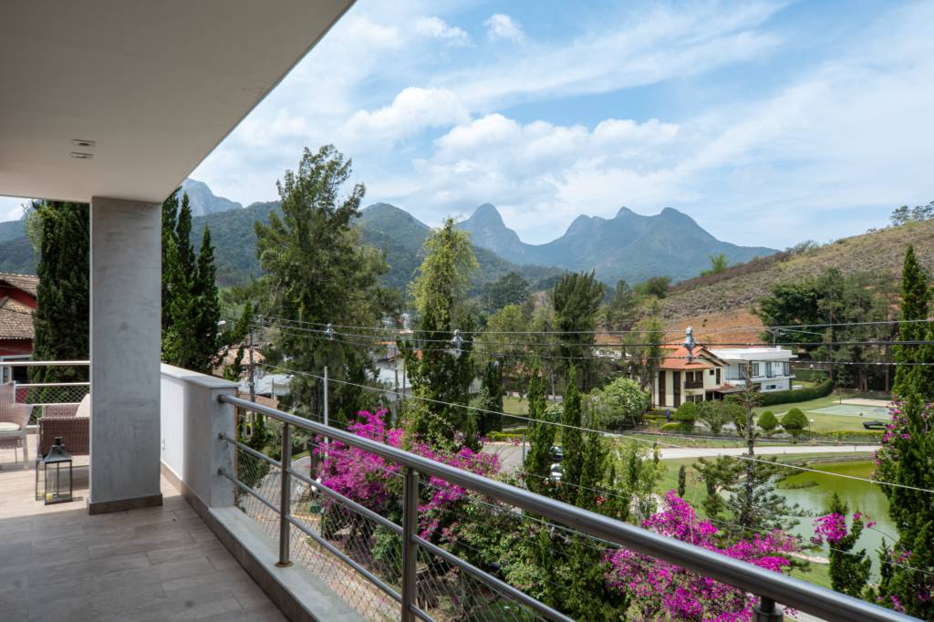 Casa em Teresópolis tem esquadrias, tijolinhos e cimento queimado na fachada. Projeto de Viviane Cunha.