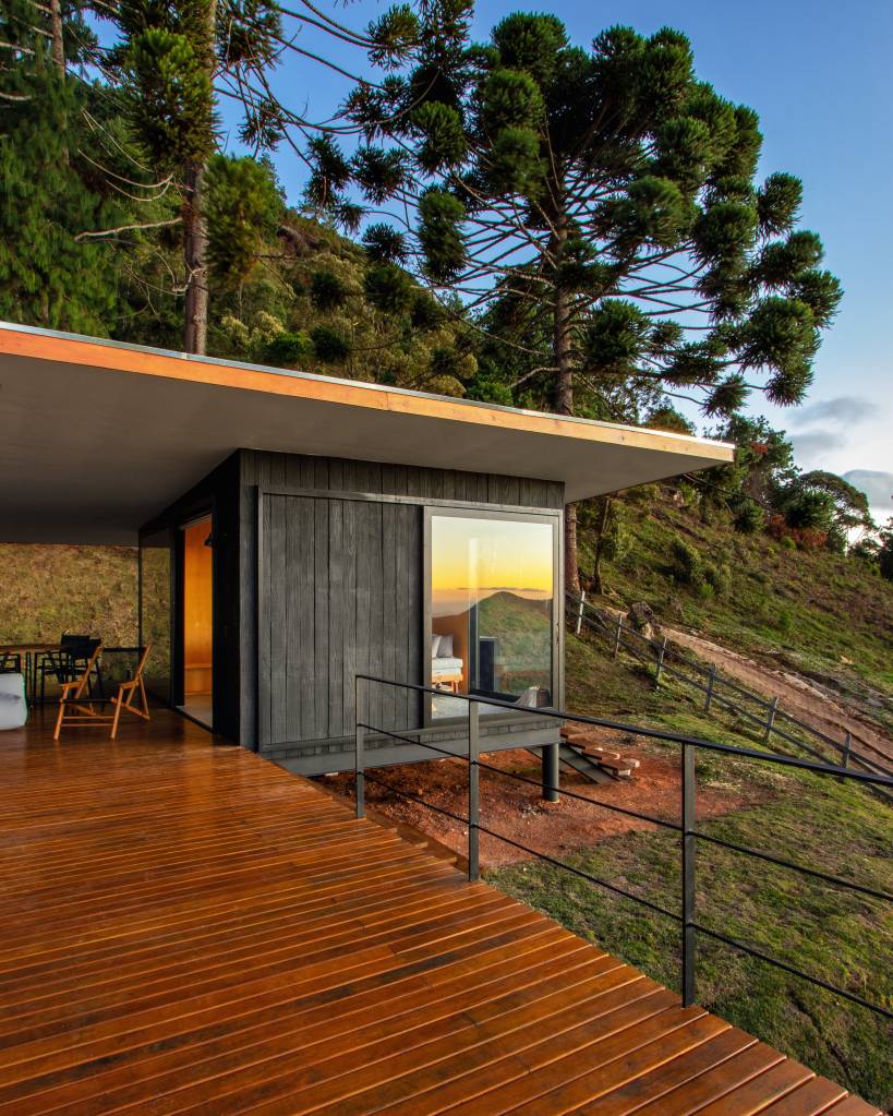 Chalé de apenas 48 m² tem paredes com painéis de madeira e vista para serra. Projeto de RAWI Arquitetura+Design. Na foto, fachada.