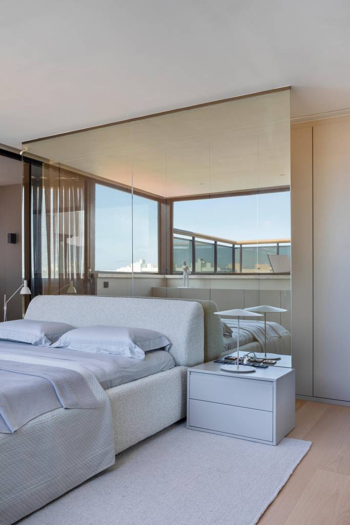 Cobertura elegante tem piso de porcelanato e escada com degraus em Dekton. Projeto BF+Arquitetos. Na foto, quarto, espelho atrás da cama.