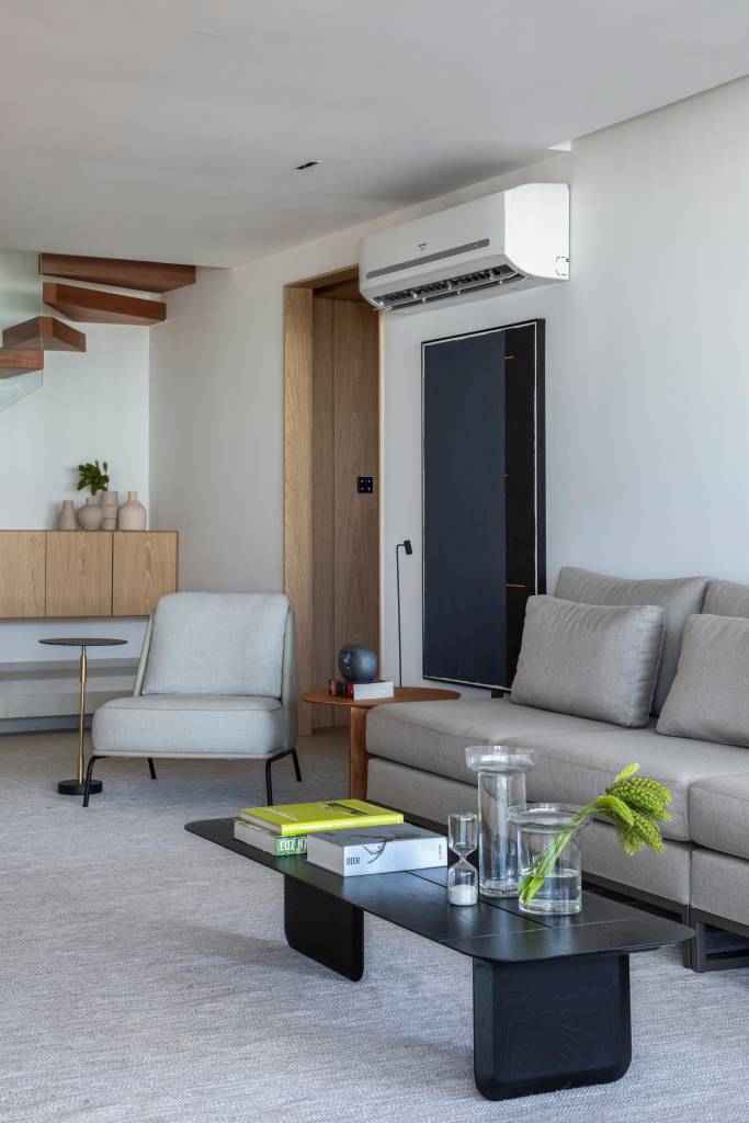 Cobertura elegante tem piso de porcelanato e escada com degraus em Dekton. Projeto BF+Arquitetos. Na foto, sala, ar condicionado.
