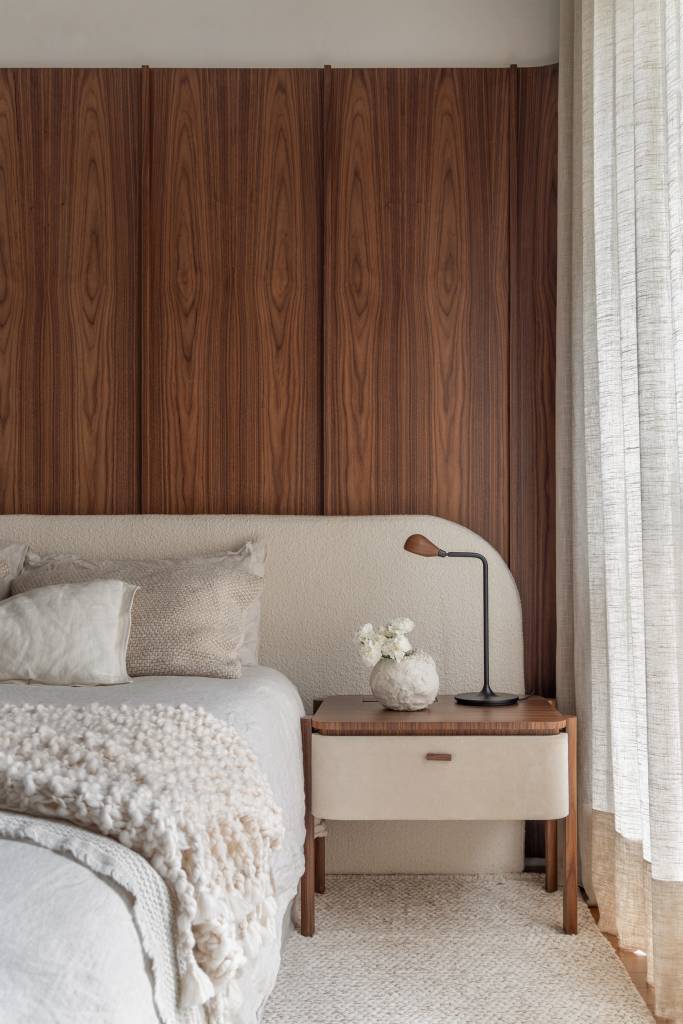 Estilo contemporâneo e design assinado são destaque em apartamento de 105 m². Projeto de Renata Niero. Na foto: suíte, mesa de cabeceira, cabeceira em painel de madeira nogueira
