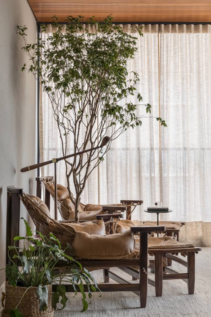 Estilo contemporâneo e design assinado são destaque em apartamento de 105 m². Projeto de Renata Niero. Na foto: sacada, poltrona jangada, poltronas, árvore em vaso