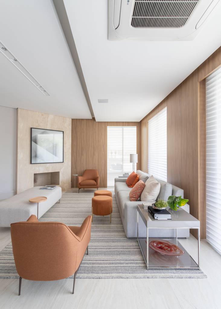 Qual tamanho o tapete deve ter em cada cômodo? Projeto de Patricia Penna Arquitetura e Design. Na foto, sala com tapete listrado.