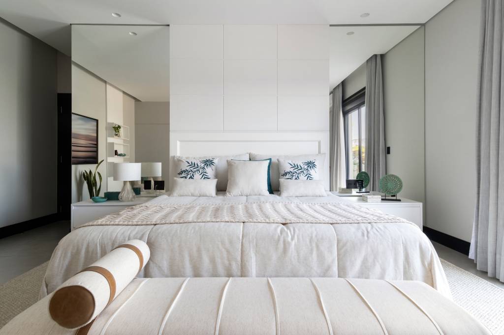 Residência de 847 m² tem projeto contemporâneo voltado ao conforto e à convivencia. Projeto de Natália Sundfeld. Na foto: casa em estilo contemporâneo, suíte, quarto, espelhos no quarto, quanrto branco