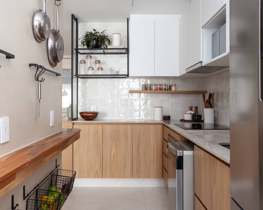 Tons de verde suave permeiam gourmet, sala e quartos neste apê. Projeto de Studio Monfré. Na foto, cozinha em formato U, marcenaria branca.
