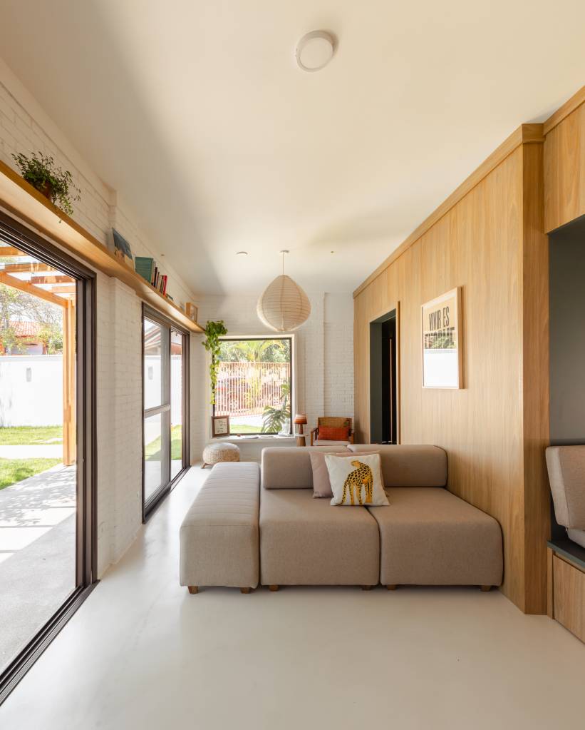 Casa com clima de praia em São José dos Campos. Projeto de escritório Sertão Arquitetos. Na foto, sala de estar com sofá central.
