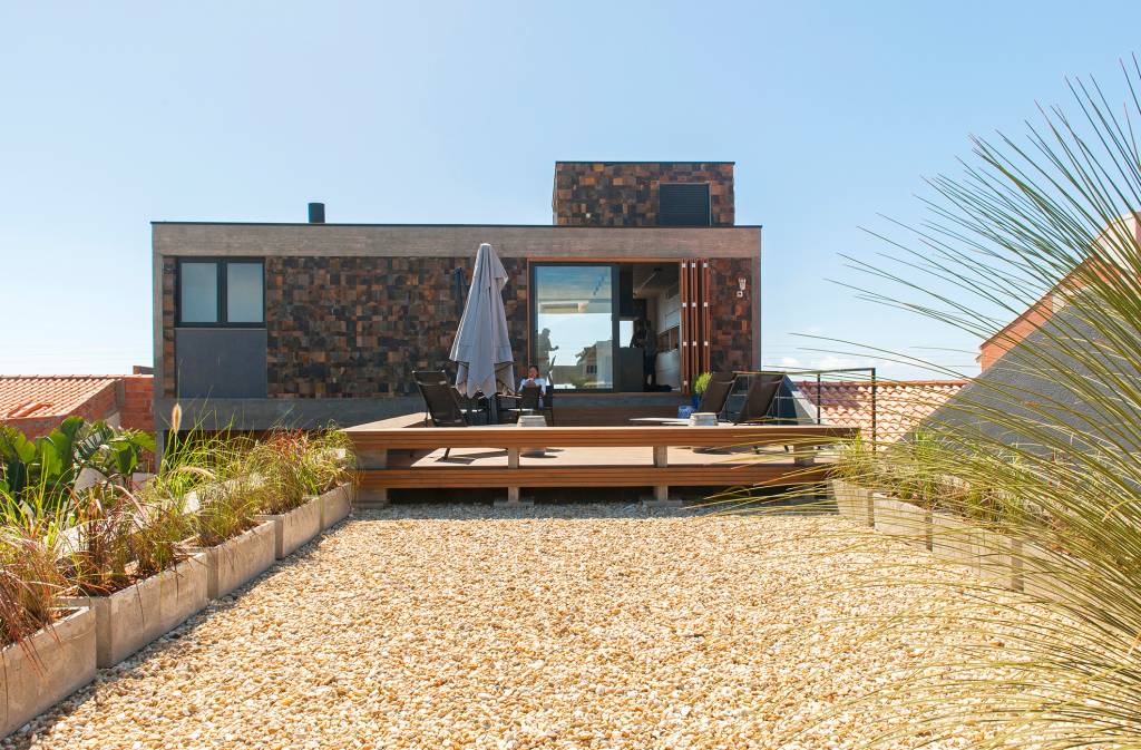 Casa-de-350-m2-e-um-mirante-com-vista-para-o-mar-Mayresse-Arquitetura-11 Casa de 350 m² é um mirante com vista para o mar. Projeto de Mayresse Arquitetura. Na foto, varanda com deck de madeira.