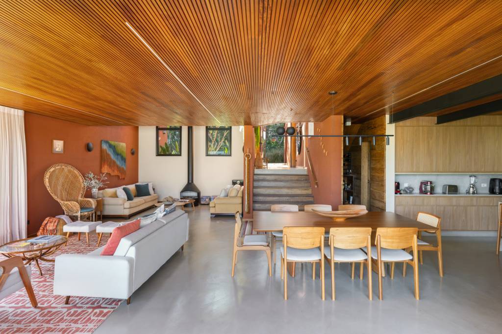Casa nos arredores de São Paulo tem tons de terracota no interior e exterior. Projeto de Sertão Arquitetos. Na foto, sala de estar e jantar integradas.