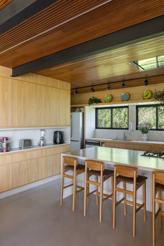 Casa nos arredores de São Paulo tem tons de terracota no interior e exterior. Projeto de Sertão Arquitetos. Na foto, sala de jantar com móvel de apoio.