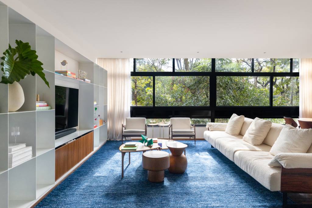 Cobogó na cozinha e no banheiro: conheça este apê em Brasília. Projeto de Maria Araújo Arquitetura e Design. Na foto, sala de estar com tapete azul.
