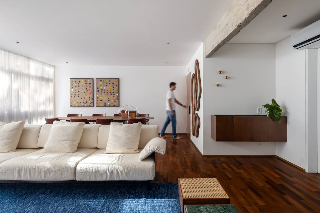 Cobogó na cozinha e no banheiro: conheça este apê em Brasília. Projeto de Maria Araújo Arquitetura e Design. Na foto, sala de estar com tapete azul.