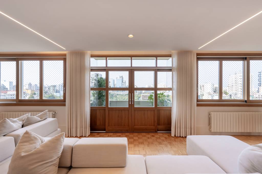 Contemporâneo, minimalista e repleto de arte: conheça este apê de 200 m². Projeto do escritório C2 Arquitetos. Na foto, sala de estar com grandes janelas.